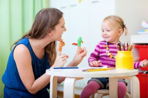 women playing with child at a table