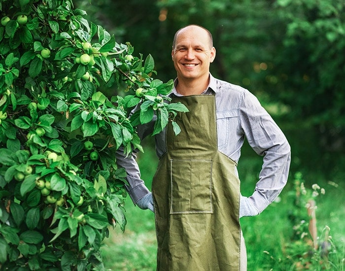 Landscaper standing next to a fruit tree