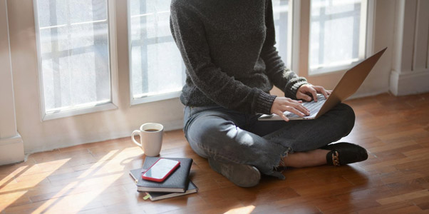 Woman Sitting on the Floor Working on a Laptop