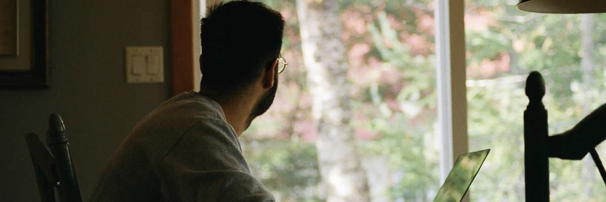 Man Looking Out Window