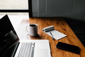 Laptop and office items resting on a wooden table