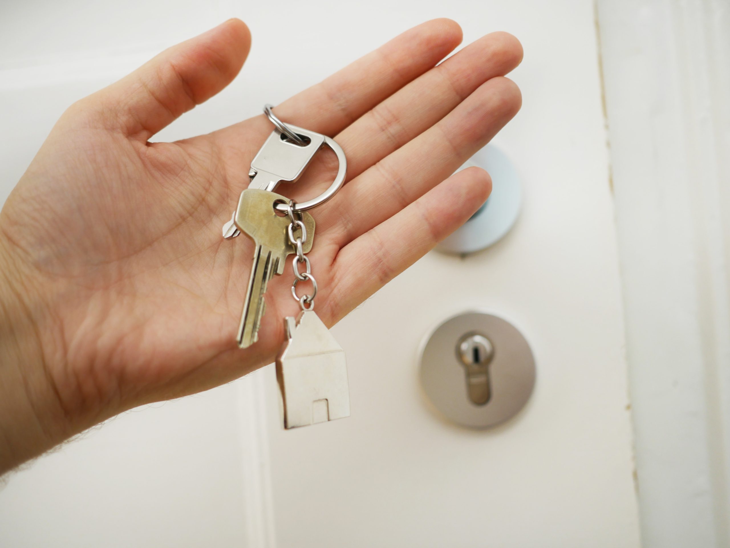 Person's hand holding house keys