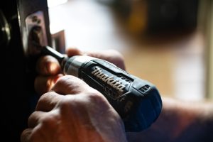 Handyman drilling into a door