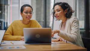 two women looking at a computer