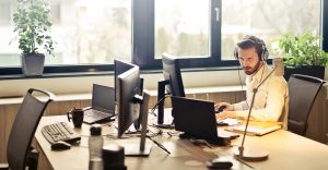 man sitting at desk looking at a computer