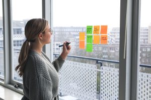 Marketing manager writing on post-it notes on a window