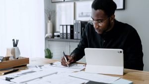 man looking at paperwork and computer on desk