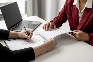 Human Resource person showing other person where to sign a document
