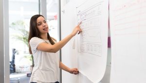 teacher pointing at a paper with information on it