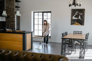 A lady cleaning the floor with a mop