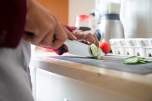 A home chef cutting up some cucumbers