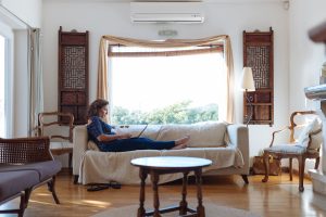 A lady sitting on the couch working on her laptop