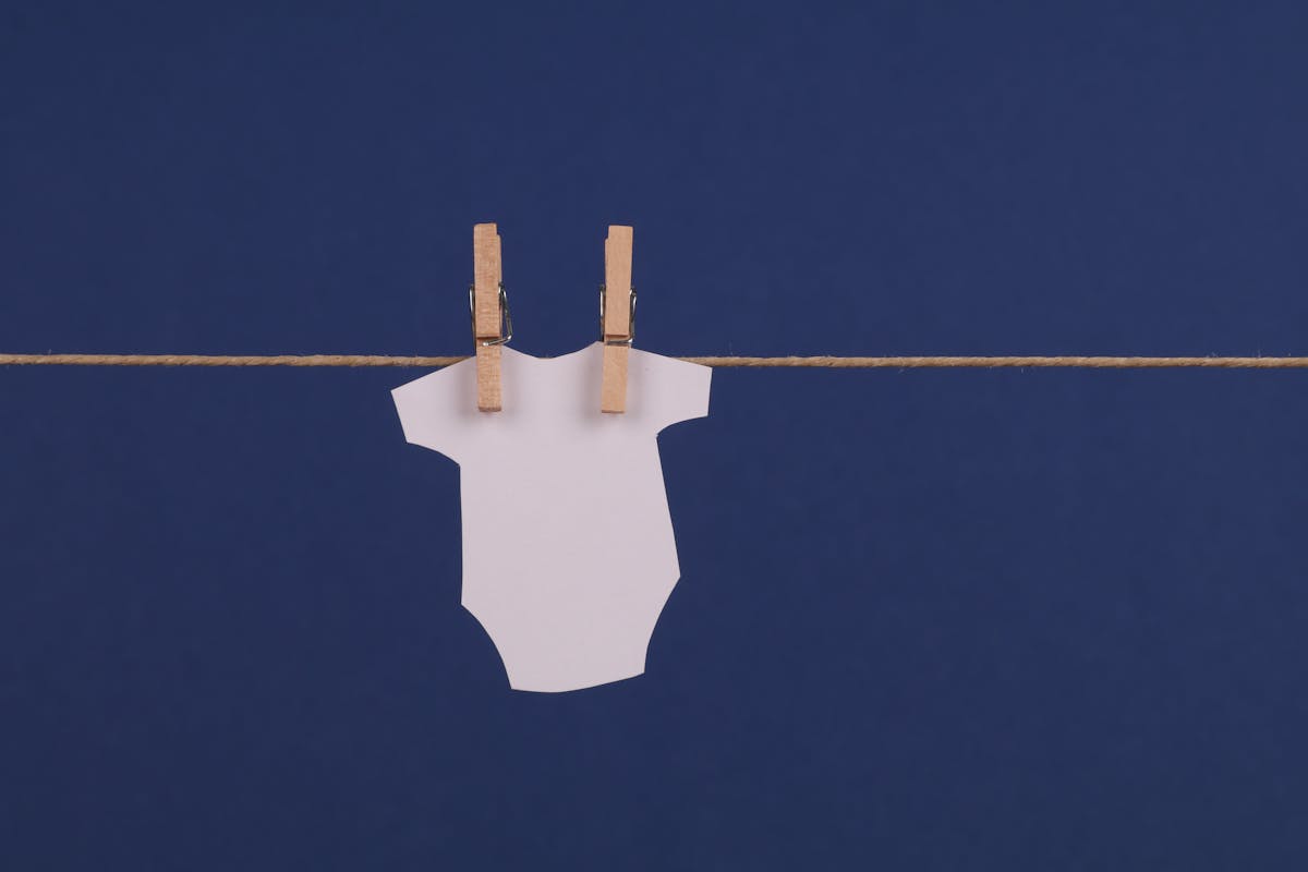 A small paper in the shape of a baby onesie