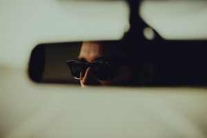 A personal driver in the rearview mirror of a car