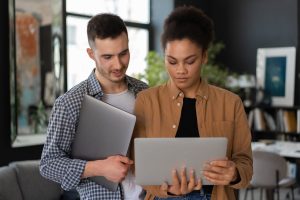 A couple people in an office looking at a screen