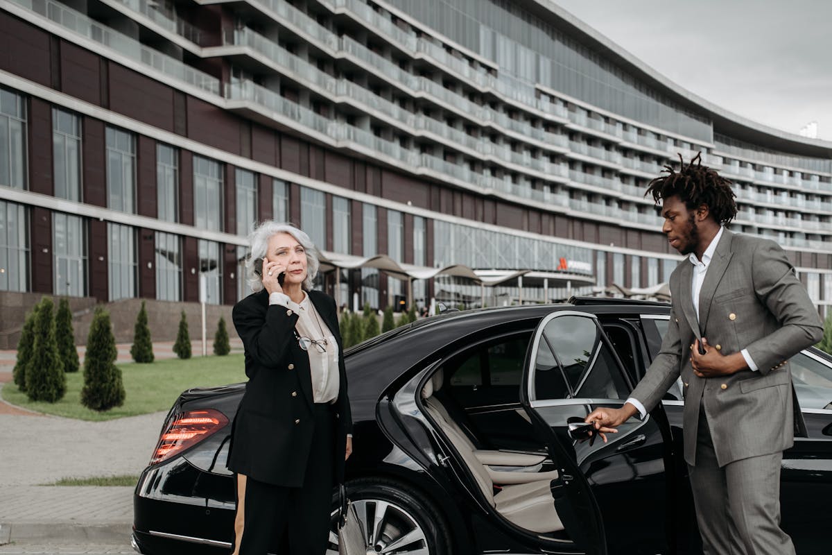 An assistant opening the car door for an executive