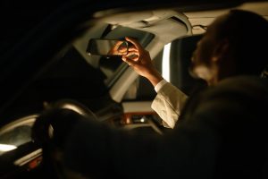 A private driver looking in his rearview mirror at night
