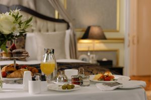 A luxury hotel room with food and drinks from room service
