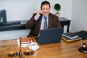 An office manager sitting in front of a laptop on a phone