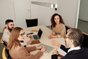 A bunch of people all talking at a table in an office