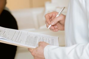 A person writing some things down on a piece of paper with a pen