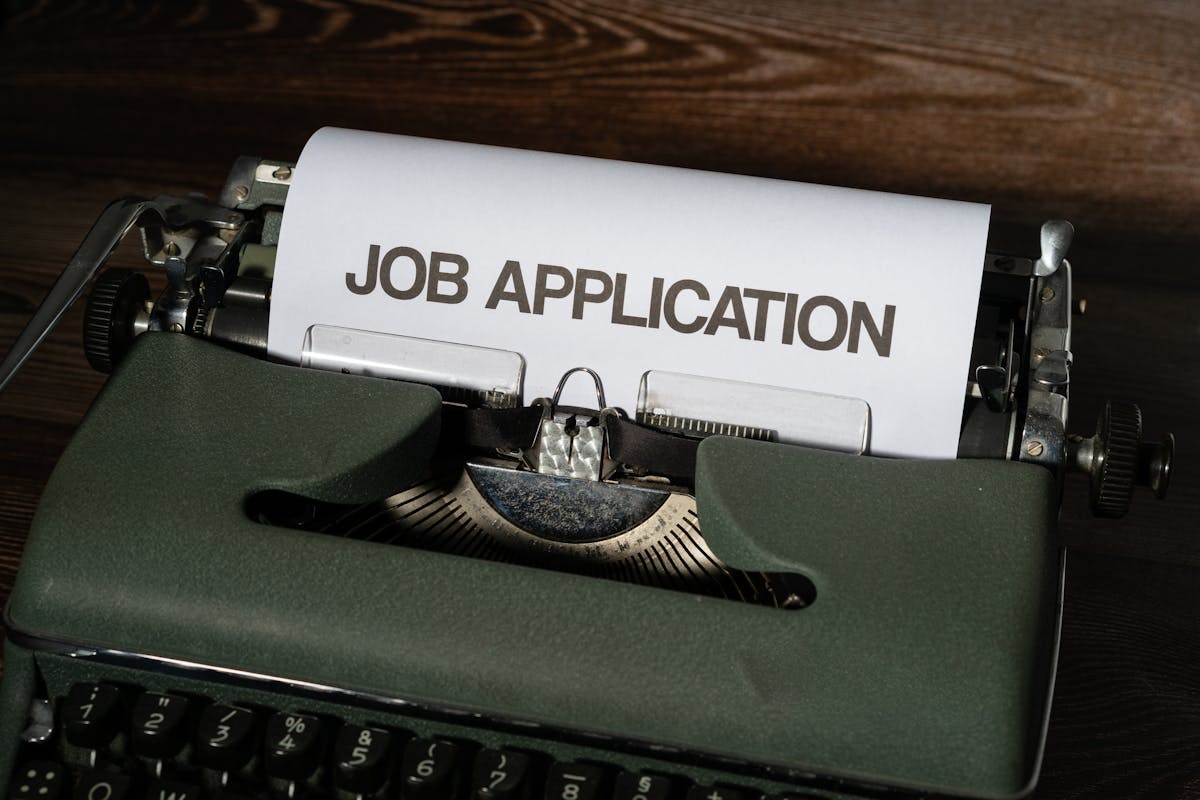 A typewriter with a paper that says job application