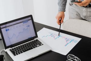 A person pointing to a piece of paper with a graph on it