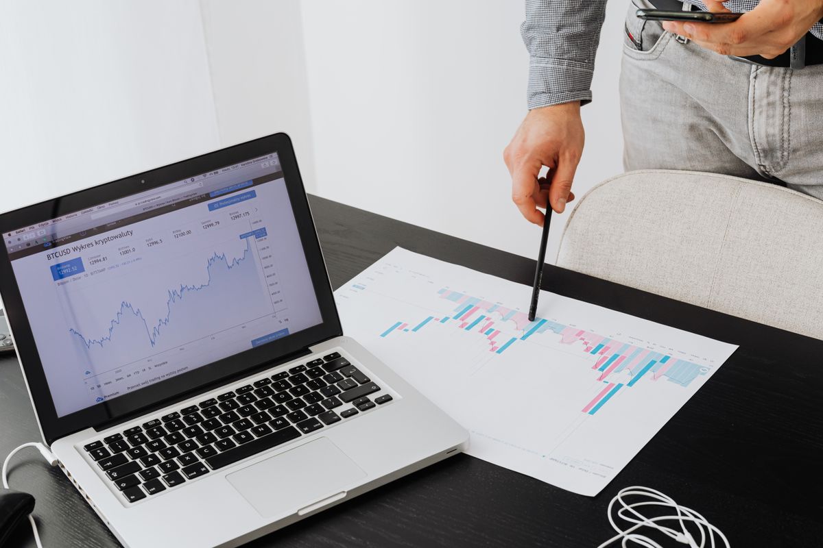 A person pointing to a piece of paper with a graph on it