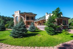 A large estate with green trees out front