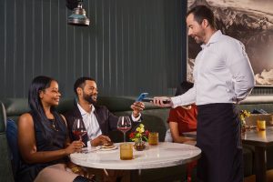 A professional server having someone pay for their food